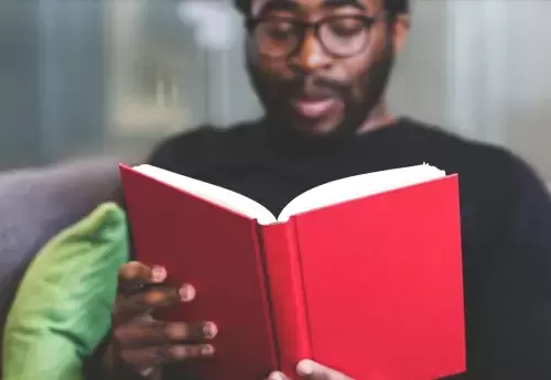 Man with glasses reading a book