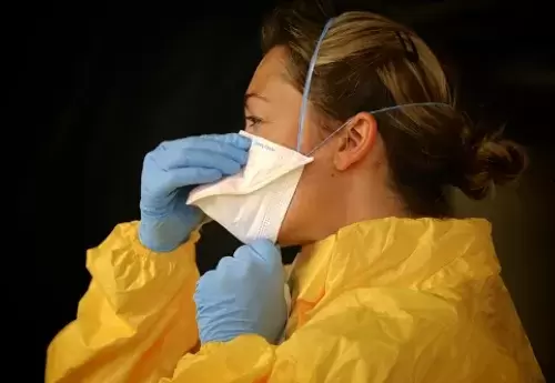 Woman in face mask and PPE