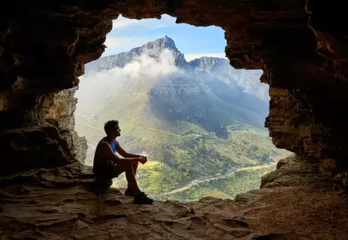 person sits in rocky cave alone